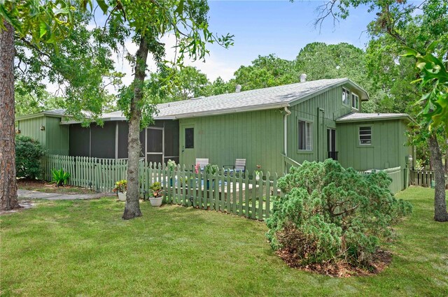 back of property featuring a sunroom and roof with shingles