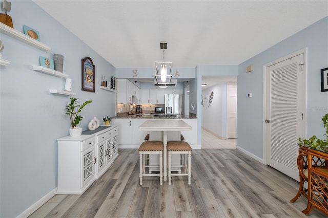 2222 Ocean Shore Blvd Unit 304B, Ormond Beach, FL 32176 - kitchen featuring light wood-style floors, white cabinetry, open shelves, and a center island