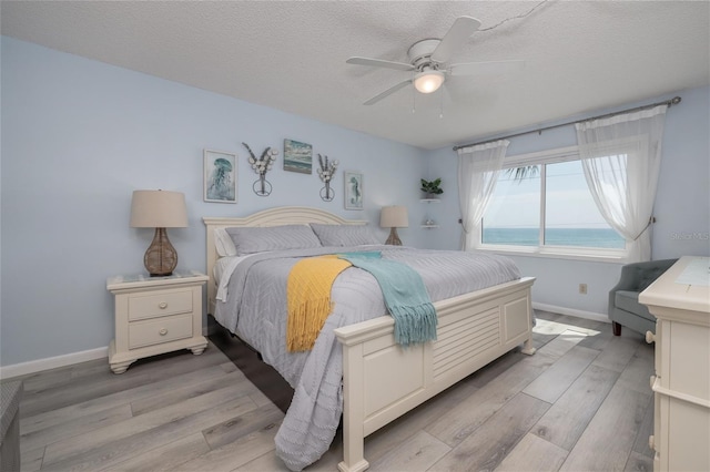 2222 Ocean Shore Blvd Unit 304B, Ormond Beach, FL 32176 - bedroom featuring light wood-type flooring, ceiling fan, and a textured ceiling