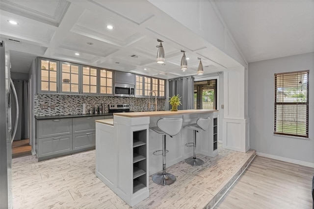 901 Vicksburg St, Deltona, FL 32725 - kitchen featuring appliances with stainless steel finishes, backsplash, a kitchen breakfast bar, butcher block countertops, and gray cabinets