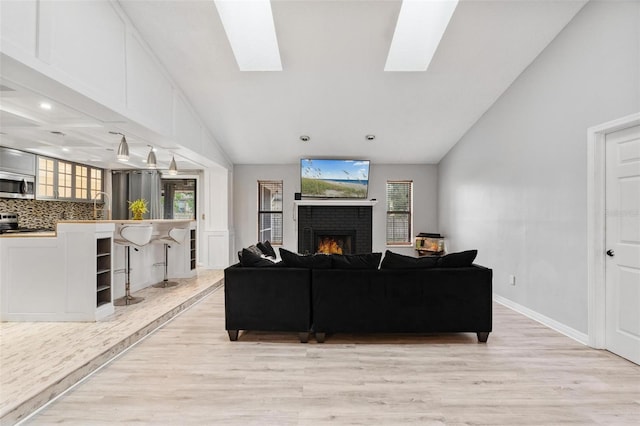 901 Vicksburg St, Deltona, FL 32725 - living room with light wood-style floors, a brick fireplace, vaulted ceiling, plenty of natural light, and a skylight