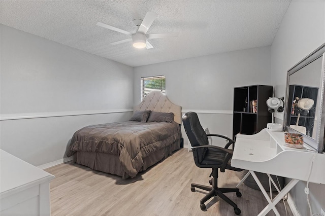 901 Vicksburg St, Deltona, FL 32725 - bedroom with a textured ceiling, light wood-type flooring, a desk, a ceiling fan, and baseboards