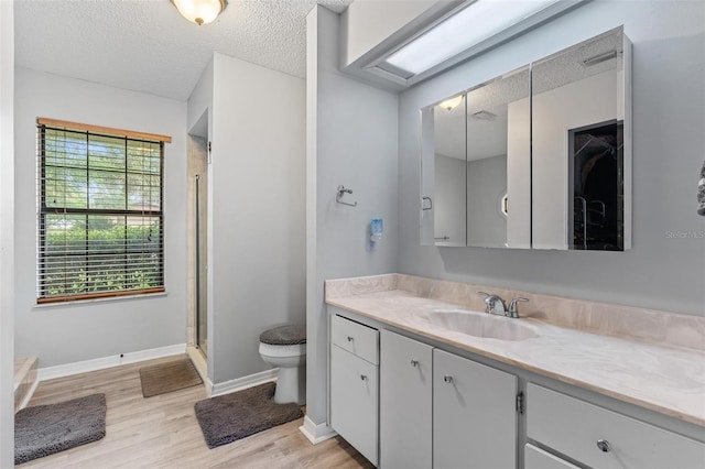 901 Vicksburg St, Deltona, FL 32725 - bathroom featuring vanity, wood finished floors, toilet, a stall shower, and a textured ceiling