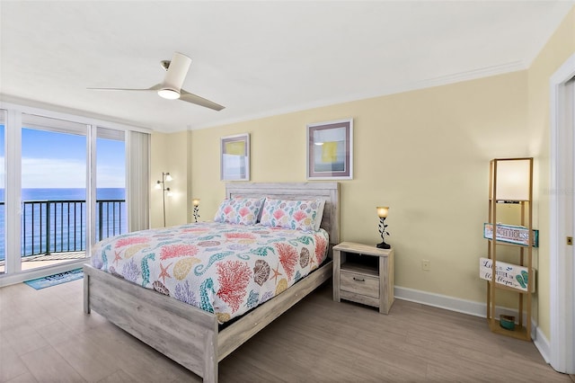 3315 S Atlantic Ave Unit 1406, Daytona Beach Shores, FL 32118 - bedroom featuring access to exterior, a water view, wood finished floors, baseboards, and crown molding