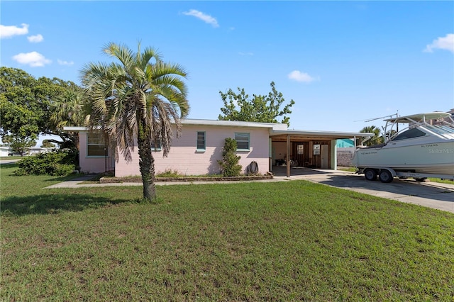 3267 S Peninsula Dr, Daytona Beach, FL 32118 - view of front facade with a carport, driveway, and a front lawn