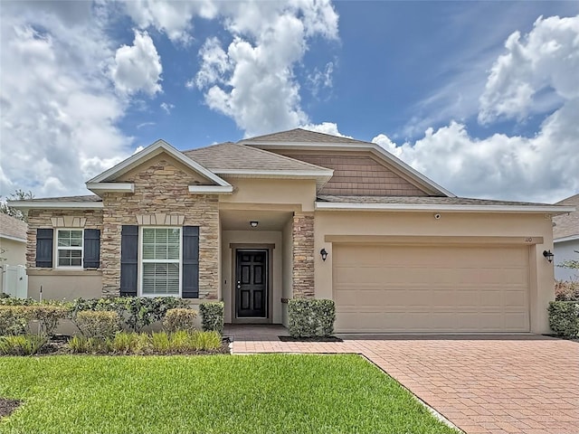 110 No Name Key Dr, Deland, FL 32720 - view of front of property with stone siding, decorative driveway, an attached garage, and a front yard