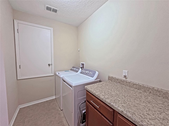 110 No Name Key Dr, Deland, FL 32720 - laundry area with washing machine and dryer, baseboards, a textured ceiling, and cabinet space