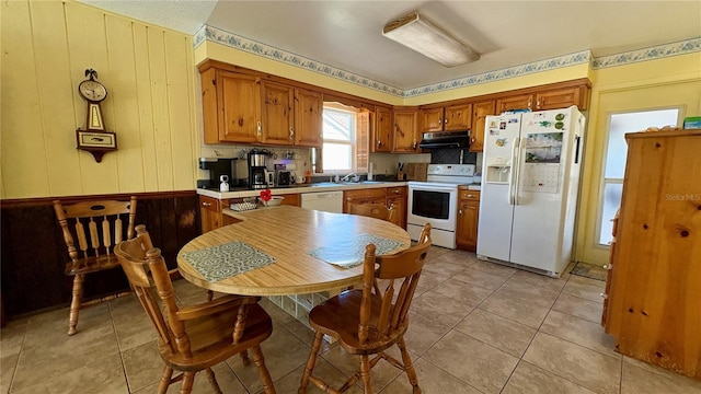 1301 Killian St, Daytona Beach, FL 32114 - kitchen with white appliances, exhaust hood, brown cabinetry, and light countertops
