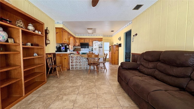 1301 Killian St, Daytona Beach, FL 32114 - living room featuring wooden walls, ornamental molding, light tile patterned floors, and a textured ceiling