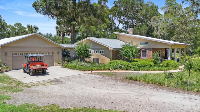 1056 Reynolds Rd, De Leon Springs, FL 32130 - view of front of house featuring driveway, a chimney, and an attached garage