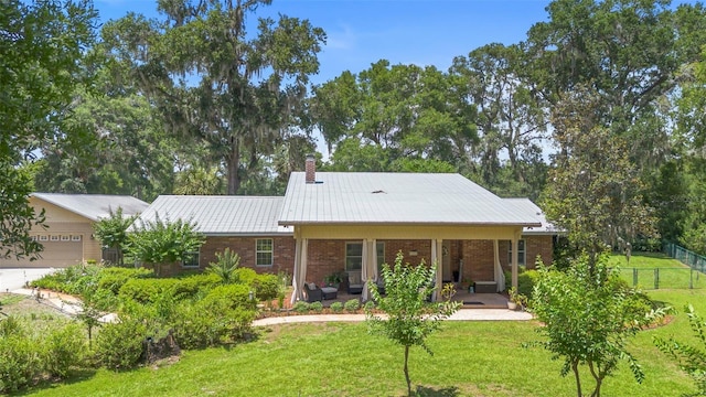 1056 Reynolds Rd, De Leon Springs, FL 32130 - view of front of property with a chimney, metal roof, brick siding, a garage, and covered porch