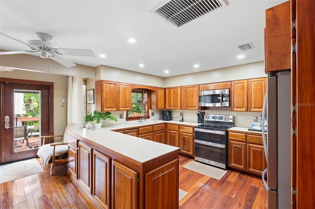 1056 Reynolds Rd, De Leon Springs, FL 32130 - kitchen with appliances with stainless steel finishes, a peninsula, wood finished floors, light countertops, and recessed lighting
