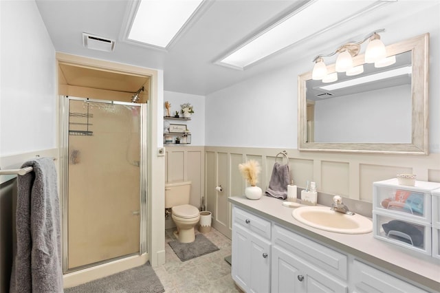 1056 Reynolds Rd, De Leon Springs, FL 32130 - bathroom featuring a stall shower, vanity, toilet, tile patterned flooring, and wainscoting