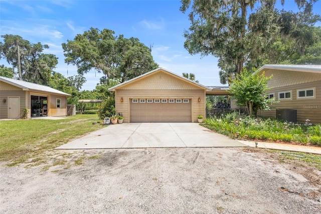 1056 Reynolds Rd, De Leon Springs, FL 32130 - view of front of house with driveway, an attached garage, a front lawn, and central AC unit