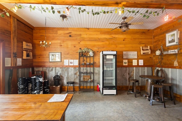 1056 Reynolds Rd, De Leon Springs, FL 32130 - living room featuring beverage cooler, unfinished concrete floors, wood walls, ceiling fan, and a chandelier