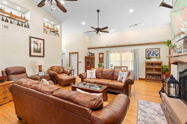 1056 Reynolds Rd, De Leon Springs, FL 32130 - living room with a ceiling fan, a towering ceiling, light wood finished floors, recessed lighting, and a large fireplace