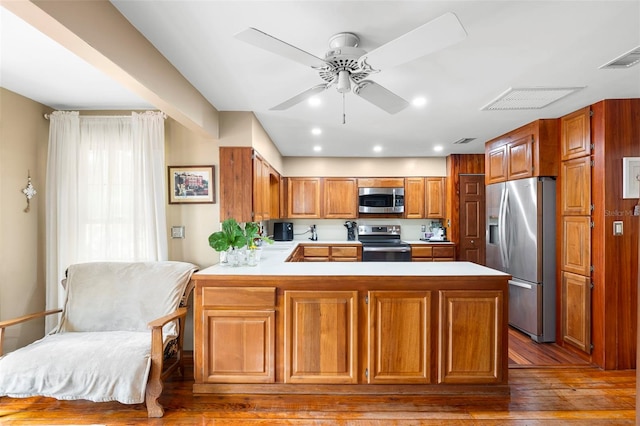 1056 Reynolds Rd, De Leon Springs, FL 32130 - kitchen with appliances with stainless steel finishes, light countertops, a peninsula, wood-type flooring, and ceiling fan