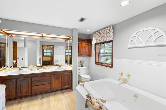 1056 Reynolds Rd, De Leon Springs, FL 32130 - full bathroom with double vanity, a whirlpool tub, wainscoting, wood finished floors, and recessed lighting