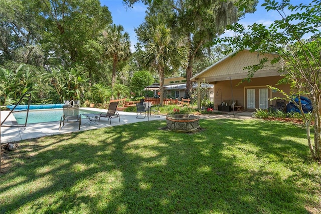 1056 Reynolds Rd, De Leon Springs, FL 32130 - view of green lawn featuring french doors, an outdoor fire pit, an outdoor pool, and a patio