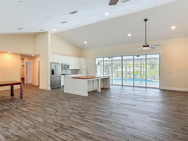 1520 Stone Trl, Enterprise, FL 32725 - kitchen featuring ceiling fan, stainless steel appliances, open floor plan, dark wood finished floors, and high vaulted ceiling
