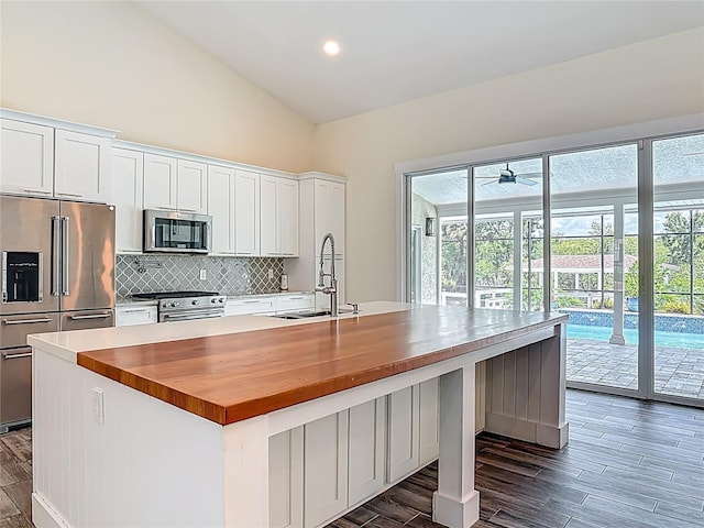 1520 Stone Trl, Enterprise, FL 32725 - kitchen with stainless steel appliances, butcher block counters, a sink, backsplash, and dark wood-style floors