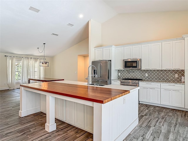 1520 Stone Trl, Enterprise, FL 32725 - kitchen featuring stainless steel appliances, butcher block countertops, a kitchen island with sink, decorative backsplash, and a sink