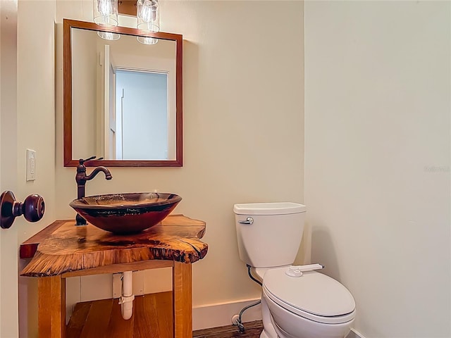 1520 Stone Trl, Enterprise, FL 32725 - half bath featuring toilet, baseboards, vanity, and wood finished floors