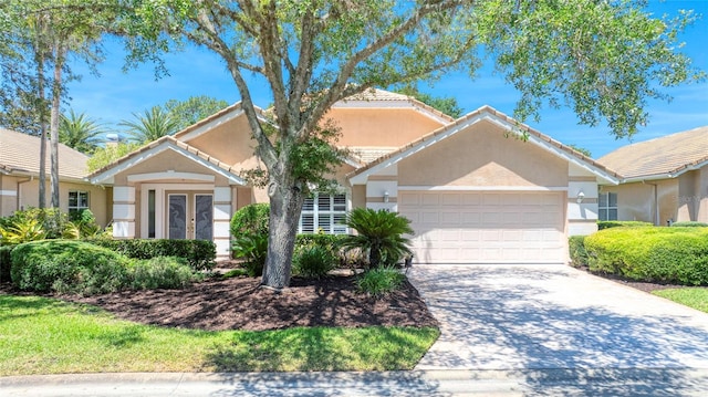 438 Harbour Town Ln, Ormond Beach, FL 32174 - view of front of house featuring a garage, stucco siding, french doors, and driveway