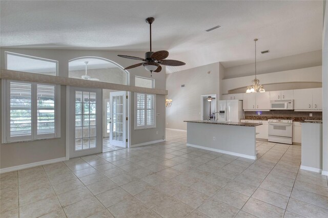 438 Harbour Town Ln, Ormond Beach, FL 32174 - kitchen with white appliances, open floor plan, light tile patterned floors, white cabinetry, and high vaulted ceiling