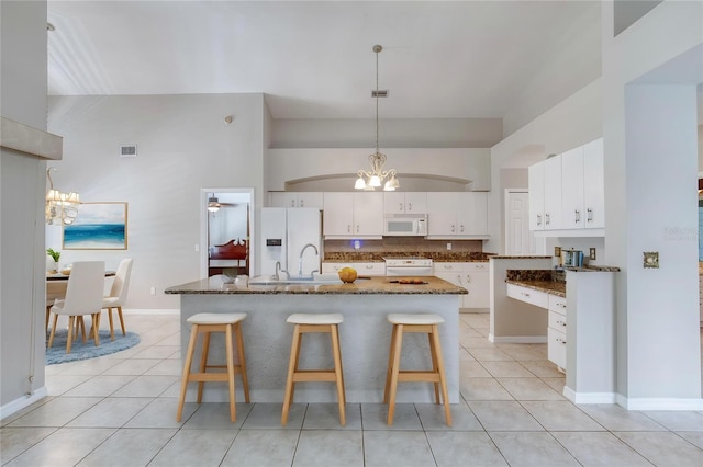 438 Harbour Town Ln, Ormond Beach, FL 32174 - kitchen featuring white appliances, a chandelier, light tile patterned floors, and decorative backsplash