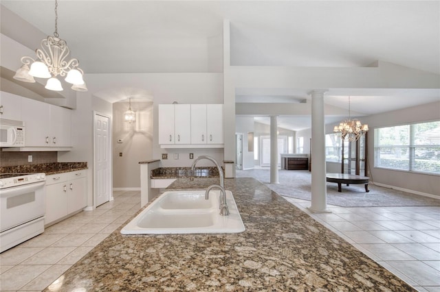 438 Harbour Town Ln, Ormond Beach, FL 32174 - kitchen with a chandelier, white appliances, a sink, light tile patterned floors, and hanging light fixtures