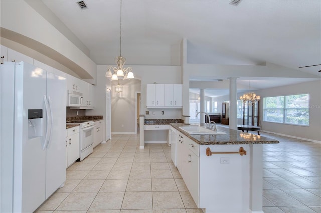 438 Harbour Town Ln, Ormond Beach, FL 32174 - kitchen with white appliances, a chandelier, a sink, light tile patterned flooring, and dark stone counters