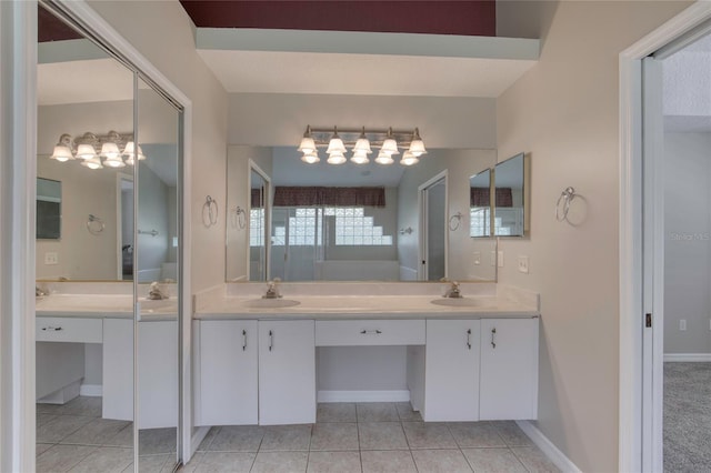 438 Harbour Town Ln, Ormond Beach, FL 32174 - bathroom featuring a chandelier, double vanity, tile patterned flooring, and baseboards