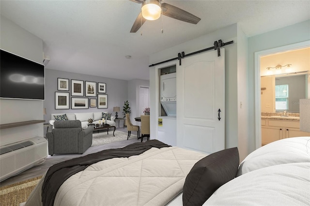 1401 S Palmetto Ave Unit 119, Daytona Beach, FL 32114 - bedroom with estacked washer and dryer, a barn door, a sink, a closet, and ceiling fan