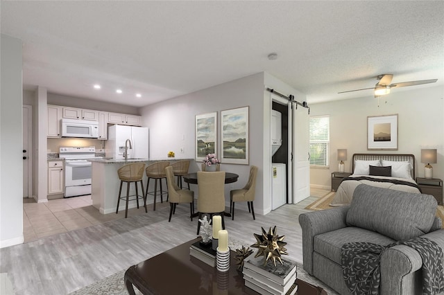 1401 S Palmetto Ave Unit 119, Daytona Beach, FL 32114 - living area featuring a barn door, light wood-style floors, baseboards, ceiling fan, and recessed lighting