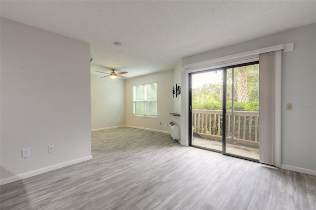1401 S Palmetto Ave Unit 119, Daytona Beach, FL 32114 - spare room featuring wood finished floors, a textured ceiling, ceiling fan, and baseboards