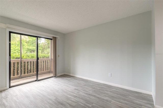 1401 S Palmetto Ave Unit 119, Daytona Beach, FL 32114 - unfurnished room featuring wood finished floors, a textured ceiling, and baseboards