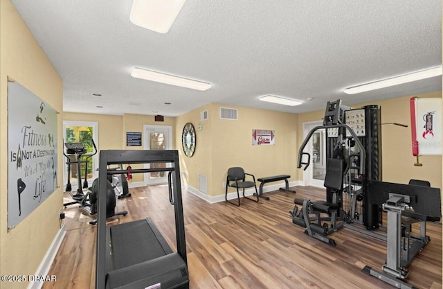 1401 S Palmetto Ave Unit 119, Daytona Beach, FL 32114 - workout room featuring a textured ceiling, wood finished floors, and baseboards