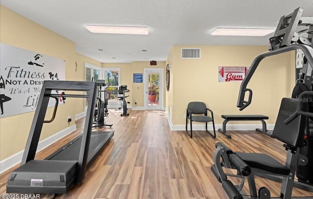 1401 S Palmetto Ave Unit 119, Daytona Beach, FL 32114 - exercise room with wood finished floors, a textured ceiling, and baseboards