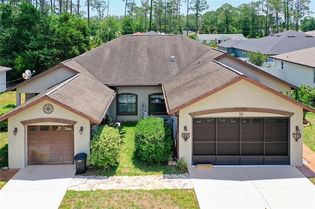 12 Emmons Ln Unit A & B, Palm Coast, FL 32164 - view of front facade featuring stucco siding, concrete driveway, a shingled roof, and an attached garage