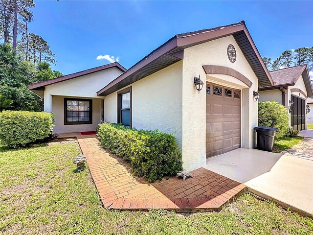 12 Emmons Ln Unit A & B, Palm Coast, FL 32164 - view of front of home with stucco siding, a garage, and driveway
