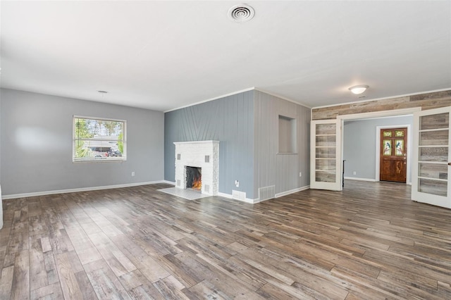 1411 Cliff Ave, Eustis, FL 32726 - unfurnished living room with a brick fireplace, wood finished floors, wood walls, baseboards, and ornamental molding