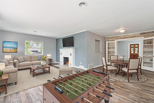 1411 Cliff Ave, Eustis, FL 32726 - playroom featuring hardwood / wood-style floors, a brick fireplace, baseboards, and wooden walls