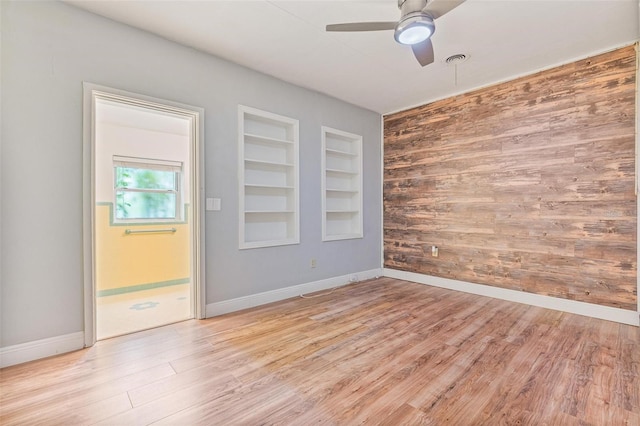 1411 Cliff Ave, Eustis, FL 32726 - empty room with ceiling fan, wood walls, built in features, baseboards, and light wood-type flooring
