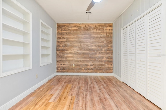 1411 Cliff Ave, Eustis, FL 32726 - unfurnished bedroom featuring wood finished floors, wood walls, baseboards, and a closet