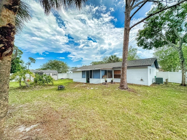1229 Jeffery Dr, Port Orange, FL 32129 - back of house featuring central AC, a sunroom, and an outdoor fire pit