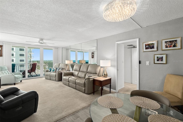 2987 S Atlantic Ave Unit 901, Daytona Beach, FL 32118 - living room with a textured ceiling, a ceiling fan, light wood-type flooring, a chandelier, and a textured wall