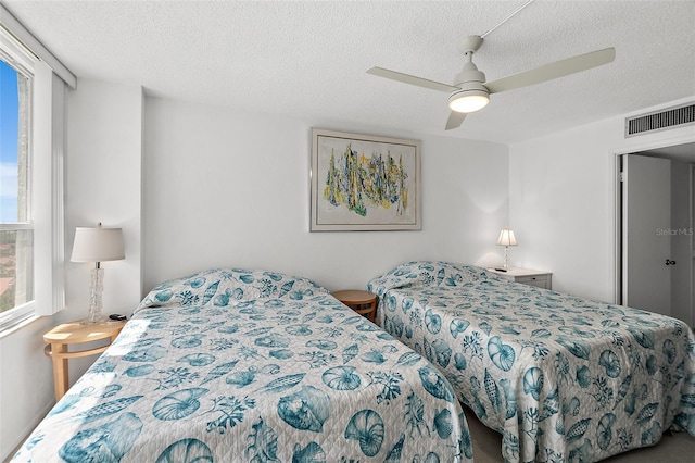2987 S Atlantic Ave Unit 901, Daytona Beach, FL 32118 - bedroom featuring multiple windows, ceiling fan, and a textured ceiling