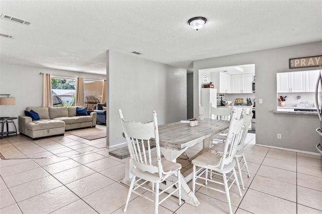 833 Lucerne Cir, Ormond Beach, FL 32174 - dining room featuring light tile patterned floors and a textured ceiling