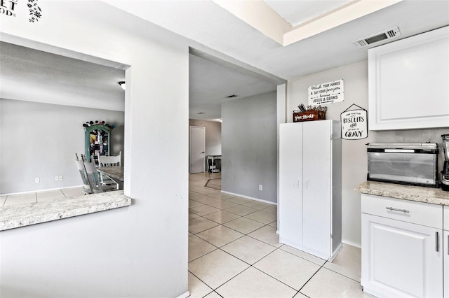 833 Lucerne Cir, Ormond Beach, FL 32174 - kitchen featuring light tile patterned floors, white cabinets, light countertops, and baseboards